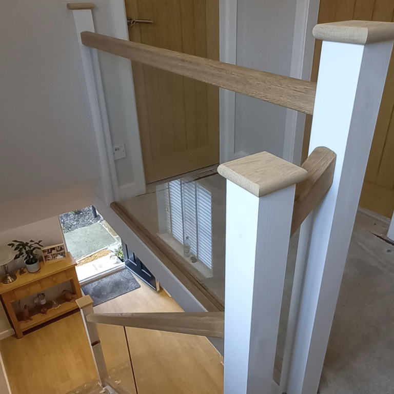 Glass and oak staircase renovation in modern hallway