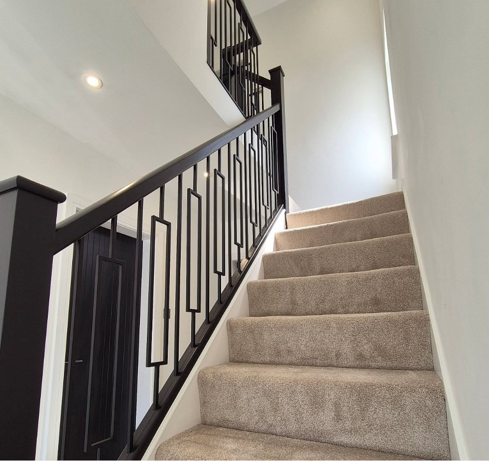 Oak staircase renovation with black metal spindles and oak handrails in Cheshire
