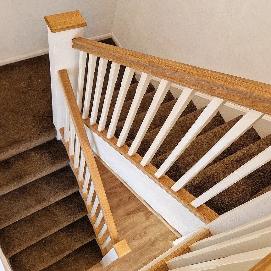 Oak and white staircase makeover with painted newel posts